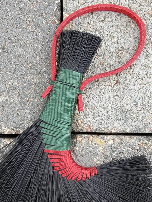 6" altar broom with dyed black fibers, woven in red and green for reversal work
